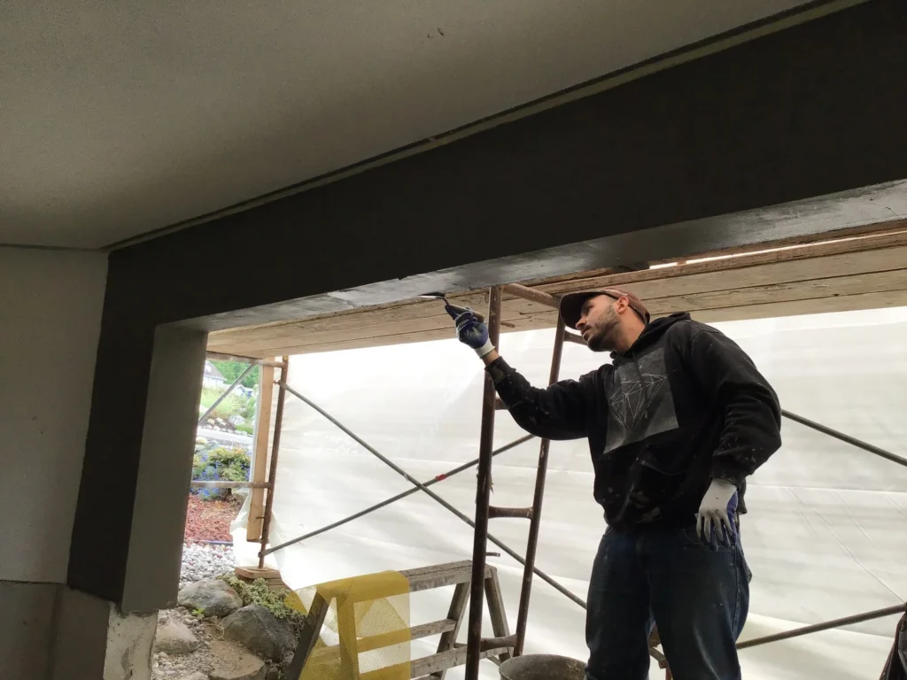 Man fixing stucco at Bellevue home