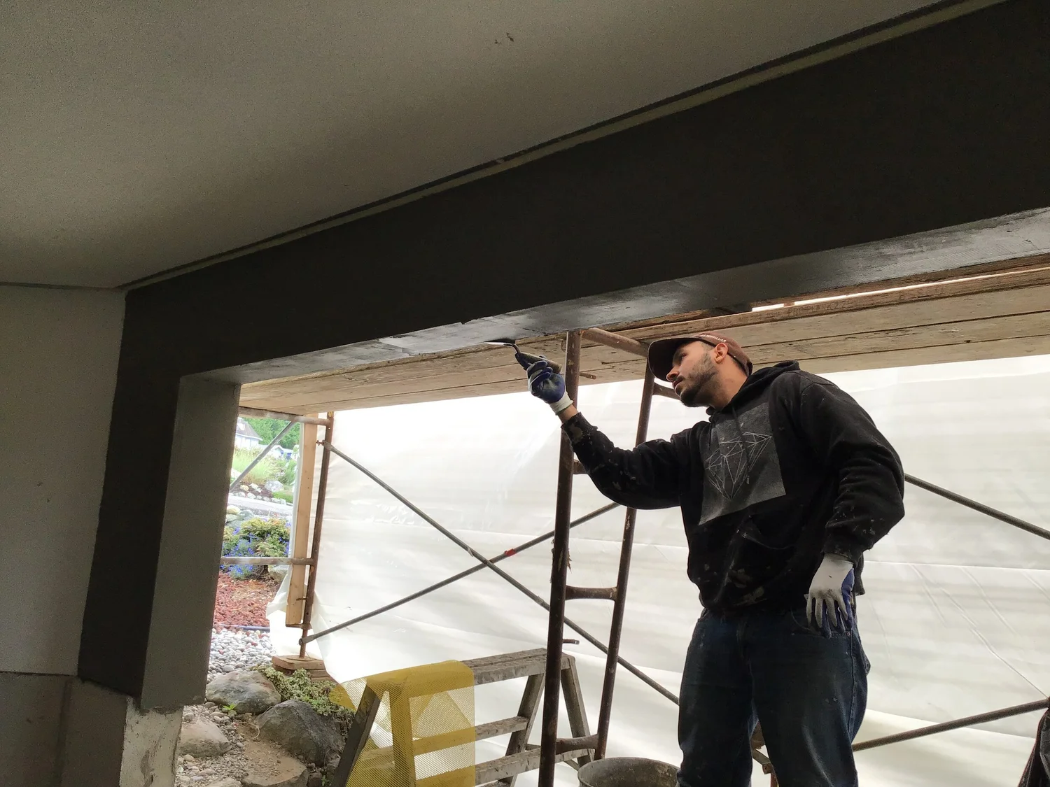 Man fixing stucco at Bellevue home